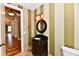 This powder room features striped walls, travertine flooring, and a custom vanity with an undermount sink at 7128 Trail Ridge Ln, Indianapolis, IN 46259