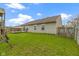 View of the backyard featuring a grassy lawn, wooden fence, and the home's exterior at 7219 Snider Ct, Indianapolis, IN 46221