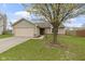 Inviting home featuring a lush front yard with a mature tree and attached two-car garage at 7219 Snider Ct, Indianapolis, IN 46221