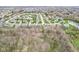 Wide aerial shot showcases the suburban neighborhood, backing onto a tree-filled nature area and pond at 7501 Independence Dr, Zionsville, IN 46077