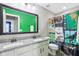 Unique bathroom with a green accent wall behind the mirror, a vibrant shower curtain, and dual sinks at 7501 Independence Dr, Zionsville, IN 46077