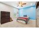 A bedroom featuring a bright blue accent wall, full bed, and ample natural light at 7501 Independence Dr, Zionsville, IN 46077