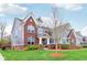 Lovely traditional home with brick and siding exterior, complemented by a lush green lawn and attractive landscaping at 7501 Independence Dr, Zionsville, IN 46077