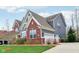 A beautiful shot showcasing the home's side exterior, including a three-car garage and pristine landscaping at 7501 Independence Dr, Zionsville, IN 46077