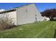 Side of the home showing the siding, lawn with dandelions, and tree at 7675 Mistflower Ln, Noblesville, IN 46062