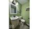 A bathroom featuring a toilet, sink and vanity with a painted green wall at 833 W Franklin St, Shelbyville, IN 46176