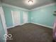 Large bedroom with neutral walls, soft carpet, and two doors at 833 W Franklin St, Shelbyville, IN 46176