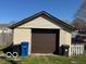 Close up view of one car garage, garbage cans and partial fence at 833 W Franklin St, Shelbyville, IN 46176