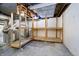 Unfinished basement featuring wooden shelving, utility pipes and concrete flooring at 908 N Bolton Ave, Indianapolis, IN 46219