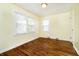 Cozy bedroom features pristine wood floors and abundant natural light from multiple windows at 908 N Bolton Ave, Indianapolis, IN 46219