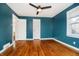 Spacious bedroom with wood floors, a ceiling fan, and two closets at 908 N Bolton Ave, Indianapolis, IN 46219