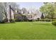 Beautiful brick house featuring a lush green lawn and mature trees at 908 N Bolton Ave, Indianapolis, IN 46219