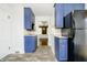 Efficient kitchen design with blue cabinetry and modern appliances at 908 N Bolton Ave, Indianapolis, IN 46219