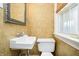 Classic powder room featuring a pedestal sink and patterned wallpaper at 908 N Bolton Ave, Indianapolis, IN 46219