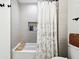 Well-lit bathroom features a tub with tile surround, shower curtain, and built in niche for storage at 9725 Thorne Cliff Way # 105, Fishers, IN 46037