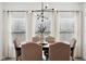 A closer view of the dining table set for six under the modern light fixture and with a neutral vase centerpiece at 9725 Thorne Cliff Way # 105, Fishers, IN 46037