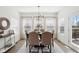 Bright dining room with light wood floors and a view to the backyard through the white-framed windows at 9725 Thorne Cliff Way # 105, Fishers, IN 46037