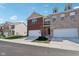 Brightly lit townhome showcasing an attached garage, brick facade, and well-manicured lawn under a clear blue sky at 9725 Thorne Cliff Way # 105, Fishers, IN 46037