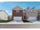 Two-story townhome showcasing an attached garage, brick facade, and well-maintained lawn on a sunny day at 9725 Thorne Cliff Way # 105, Fishers, IN 46037