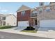 Charming townhome showcasing an attached garage, brick facade, and well-manicured lawn under a bright sunny sky at 9725 Thorne Cliff Way # 105, Fishers, IN 46037