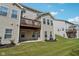 View of the rear exterior highlighting the deck, patio, and the green, sloping lawn at 9725 Thorne Cliff Way # 105, Fishers, IN 46037