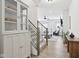 Inviting foyer with stylish cabinet and staircase, flowing into a brightly lit living space with contemporary furnishings at 9725 Thorne Cliff Way # 105, Fishers, IN 46037