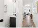 Modern hallway with a sleek vanity and mirror, leading to a spacious living area with wood-style flooring and staircase at 9725 Thorne Cliff Way # 105, Fishers, IN 46037