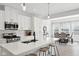 Bright, white kitchen with quartz countertops, stainless steel appliances, island with seating, and an eat-in dining area at 9725 Thorne Cliff Way # 105, Fishers, IN 46037