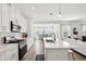 Bright, white kitchen boasts stainless steel appliances, an island with bar seating, and an open floor plan at 9725 Thorne Cliff Way # 105, Fishers, IN 46037