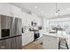 Bright, white kitchen with stainless steel appliances, an island with seating, and eat-in dining area at 9725 Thorne Cliff Way # 105, Fishers, IN 46037