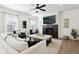 Bright living room featuring a fireplace, ceiling fan, and large ottoman for relaxing and entertaining at 9725 Thorne Cliff Way # 105, Fishers, IN 46037