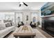 Inviting living room with a fireplace, large ottoman, and dining area in the background at 9725 Thorne Cliff Way # 105, Fishers, IN 46037