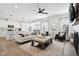 Open-concept living room with ample seating, a ceiling fan, and a seamless transition to the kitchen and dining area at 9725 Thorne Cliff Way # 105, Fishers, IN 46037
