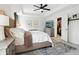 Spacious main bedroom featuring a tray ceiling, ceiling fan, neutral walls, and view into walk-in closet at 9725 Thorne Cliff Way # 105, Fishers, IN 46037
