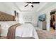Spacious main bedroom featuring a tray ceiling, ceiling fan, neutral walls, and view into walk-in closet at 9725 Thorne Cliff Way # 105, Fishers, IN 46037