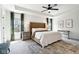 Spacious main bedroom featuring a tray ceiling, ceiling fan, neutral walls, and large windows at 9725 Thorne Cliff Way # 105, Fishers, IN 46037
