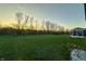 Expansive backyard featuring lush green grass, mature trees, and a charming sunroom at 9800 Ridgecrest Ln, McCordsville, IN 46055