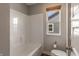 Bright bathroom featuring a tub and shower combo with a view from the window at 9800 Ridgecrest Ln, McCordsville, IN 46055