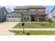 Charming two-story home with gray siding, a well-manicured lawn, and a concrete driveway at 9800 Ridgecrest Ln, McCordsville, IN 46055