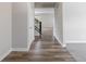 Hallway with wood floors leads past staircase and into carpeted room at 9800 Ridgecrest Ln, McCordsville, IN 46055