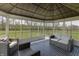 Bright sunroom with stylish wicker furniture and panoramic views of the lush backyard at 9800 Ridgecrest Ln, McCordsville, IN 46055