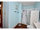 This bathroom features a shower with glass door, a cabinet and a light-blue accent wall at 1008 E Apple Lake Dr, Greenfield, IN 46140