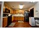 Spacious kitchen offers wood cabinets, black appliances, and a bright overhead light at 1008 E Apple Lake Dr, Greenfield, IN 46140