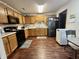 Bright kitchen features wood cabinets, laminate flooring, and sleek black appliances at 1008 E Apple Lake Dr, Greenfield, IN 46140