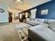 Inviting living room features carpet, a gray sectional, and a stylish accent wall at 1008 E Apple Lake Dr, Greenfield, IN 46140