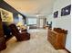 Spacious living room featuring carpet, dark blue accent wall, sectional, and a comfortable recliner at 1008 E Apple Lake Dr, Greenfield, IN 46140