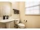 Cozy powder room features a pedestal sink, modern fixtures, and natural light from the window at 1057 3Rd Nw Ave, Carmel, IN 46032