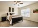 Cozy bedroom features comfortable bedding, a ceiling fan, and natural light from the window at 1057 3Rd Nw Ave, Carmel, IN 46032