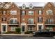 Charming brick townhouse featuring black shutters, dormer windows, and a well-maintained front garden at 1057 3Rd Nw Ave, Carmel, IN 46032