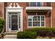 Close-up of the front entrance, showcasing a black door, sidelights, and a manicured garden at 1057 3Rd Nw Ave, Carmel, IN 46032